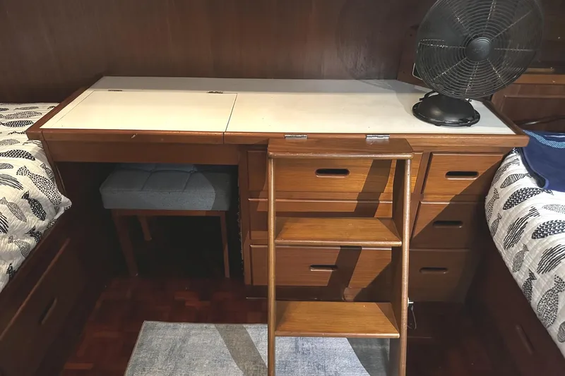 Slide: The Image of 1979 Grand Banks 42 Classic cabin interior with wooden desk, drawers, and fan. - 37