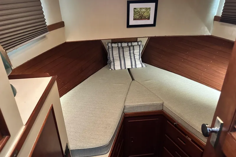 Slide: The Image of 1979 Grand Banks 42 Classic cabin interior with cozy V-berth and striped pillow. - 40