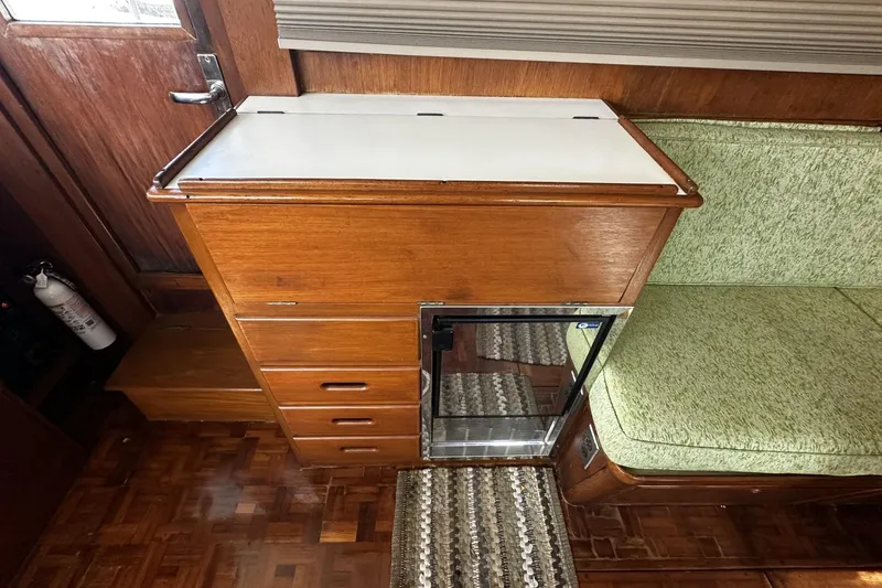 Slide: The Image of 1979 Grand Banks 42 Classic interior with wooden cabinetry and green seating. - 44