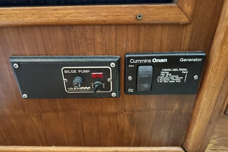Slide: The Image of Control panel of a 1979 Grand Banks 42 Classic boat, featuring bilge pump and Cummins Onan generator. - 50
