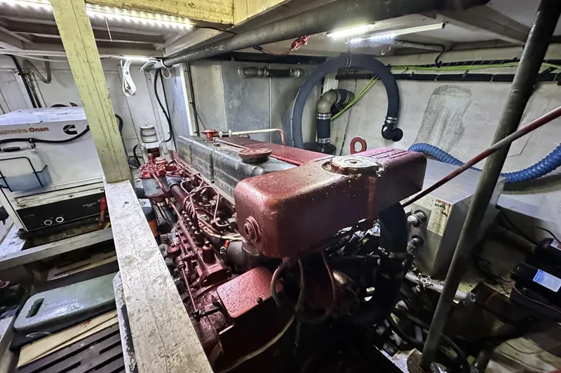 Slide: The Image of Engine room of a 1979 Grand Banks 42 Classic yacht, featuring a Cummins Onan generator. - 52
