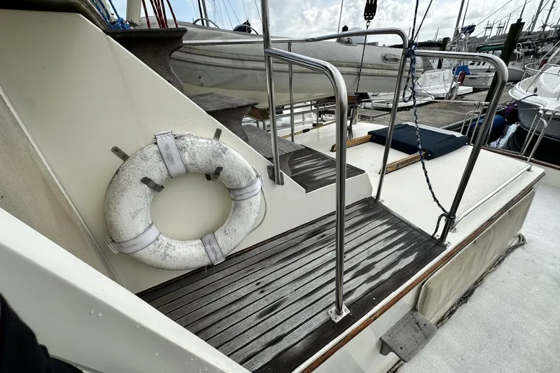 Slide: The Image of 1979 Grand Banks 42 Classic yacht deck with life ring and wooden steps. - 8