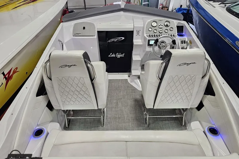 Slide: The Image of 2018 Baja 24 Outlaw boat interior with white seating and modern dashboard controls. - 101