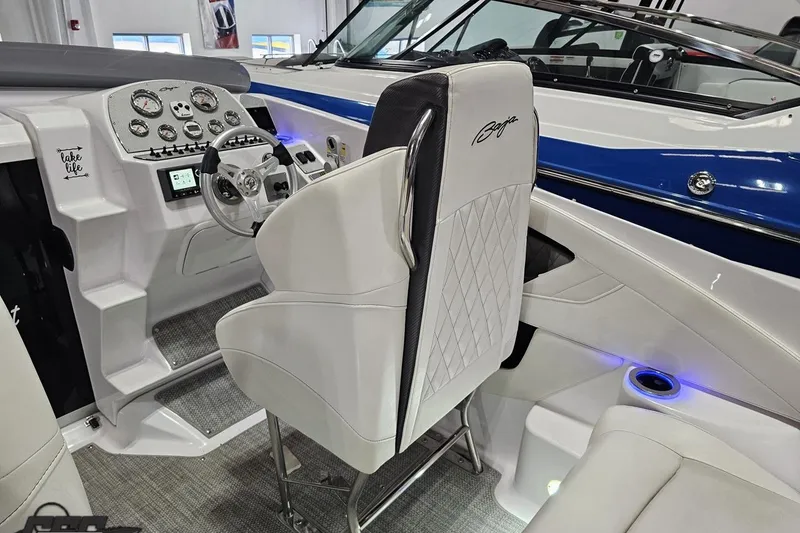 Slide: The Image of 2018 Baja 24 Outlaw boat interior with white seating, modern dashboard, and blue accents. - 104