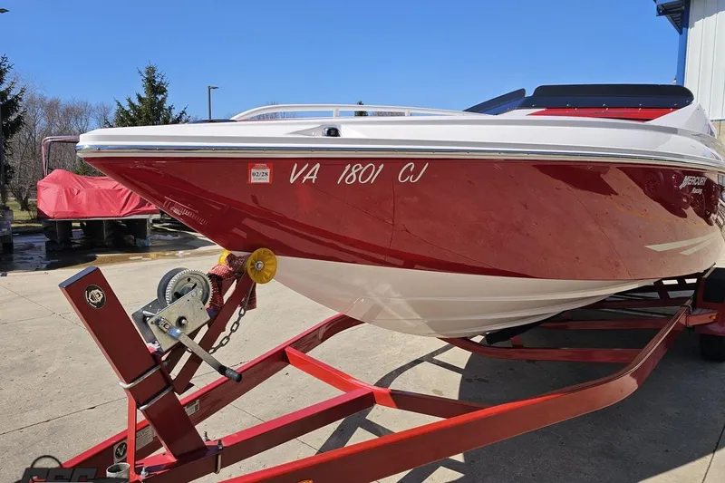 Slide: The Image of 2018 Baja 24 Outlaw boat on trailer, red and white design, parked outdoors. - 16