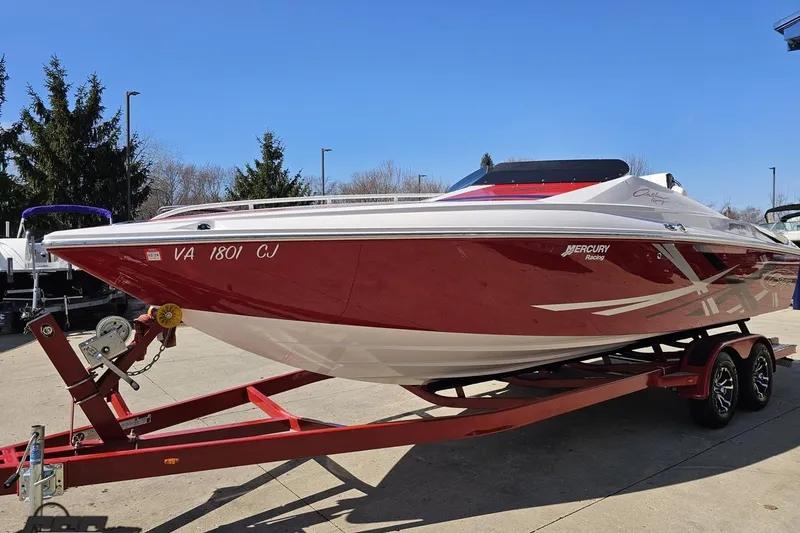 Slide: The Image of 2018 Baja 24 Outlaw boat on trailer, red and white design, parked outdoors. - 18