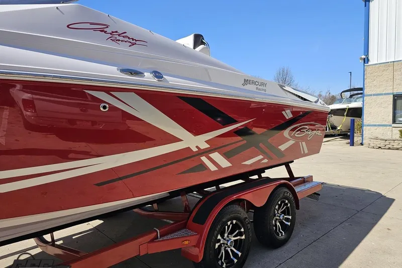 Slide: The Image of 2018 Baja 24 Outlaw boat with red and white graphics on a trailer. - 21