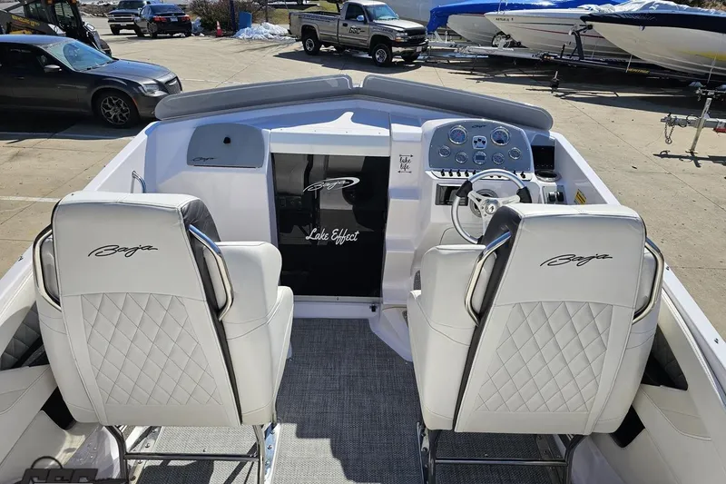 Slide: The Image of 2018 Baja 24 Outlaw boat interior with white leather seats and dashboard controls. - 54