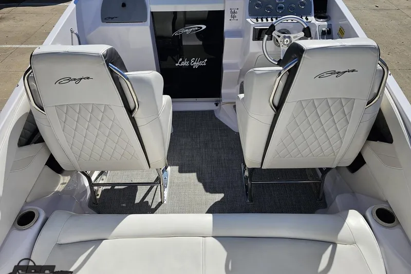 Slide: The Image of 2018 Baja 24 Outlaw boat interior with white quilted seats and steering console. - 55