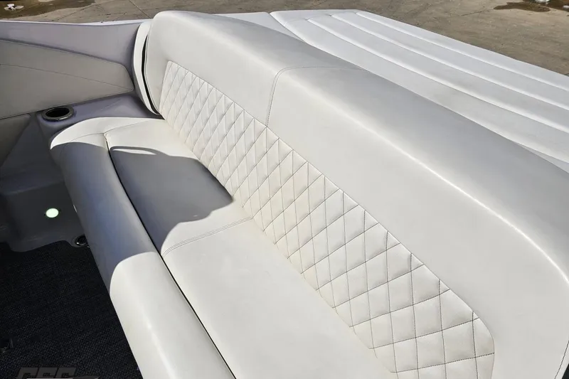 Slide: The Image of 2018 Baja 24 Outlaw boat interior with white quilted upholstery and cup holder. - 56