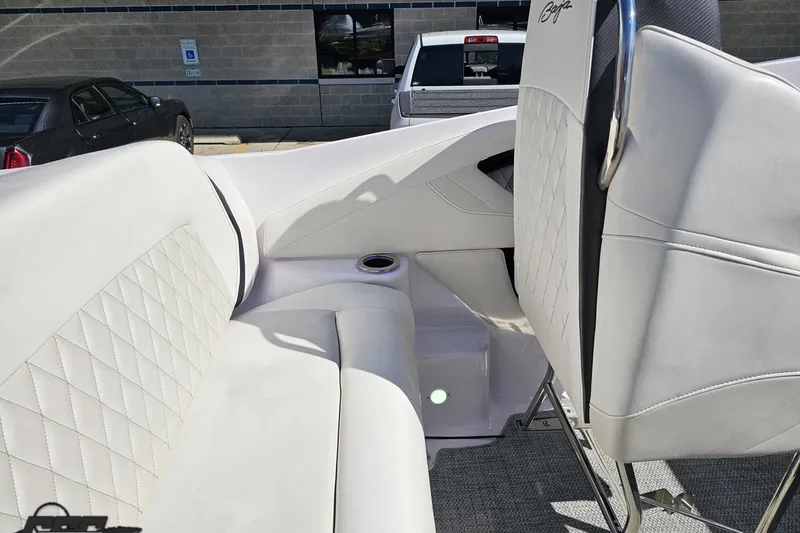 Slide: The Image of Interior of a 2018 Baja 24 Outlaw boat with white seating and cup holder. - 59