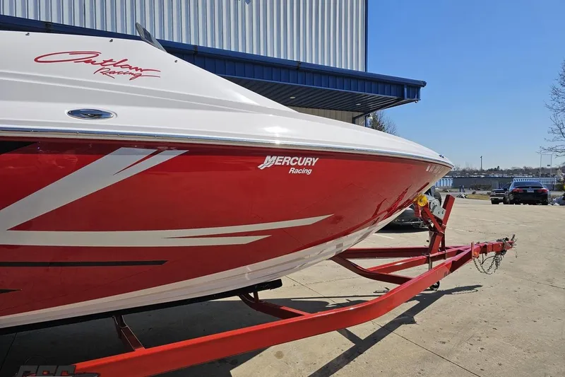 Slide: The Image of 2018 Baja 24 Outlaw boat with red and white design on a trailer. - 6