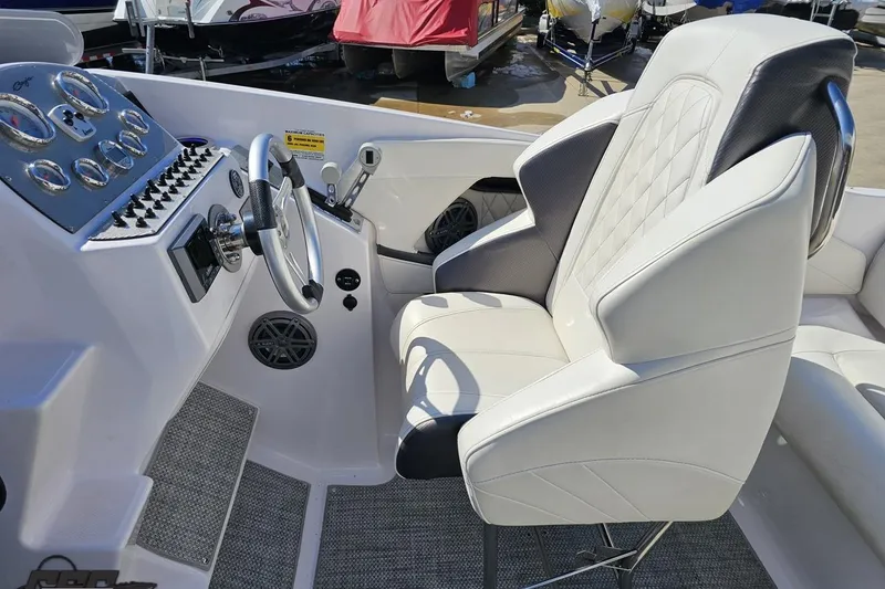 Slide: The Image of Interior of a 2018 Baja 24 Outlaw boat featuring a sleek steering wheel and plush seating. - 65