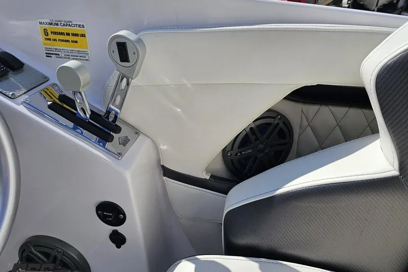 Slide: The Image of Interior of a 2018 Baja 24 Outlaw boat with controls and speaker. - 67