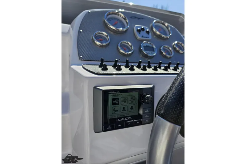 Slide: The Image of Dashboard of a 2018 Baja 24 Outlaw boat with gauges and JL Audio system. - 71