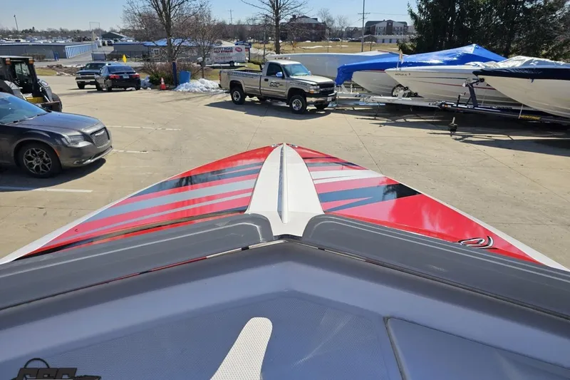 Slide: The Image of 2018 Baja 24 Outlaw boat with red and black stripes in a parking lot. - 78