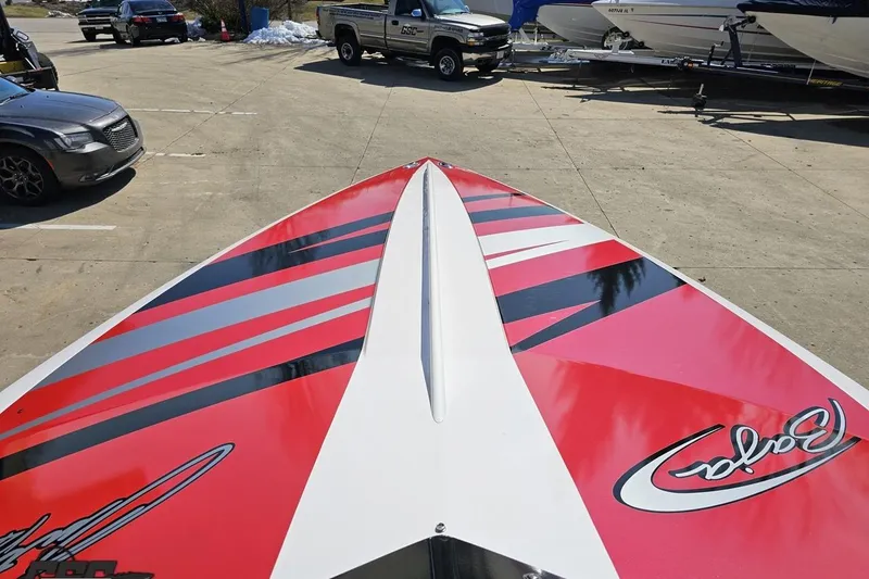 Slide: The Image of 2018 Baja 24 Outlaw boat with red and black stripes on a trailer. - 79