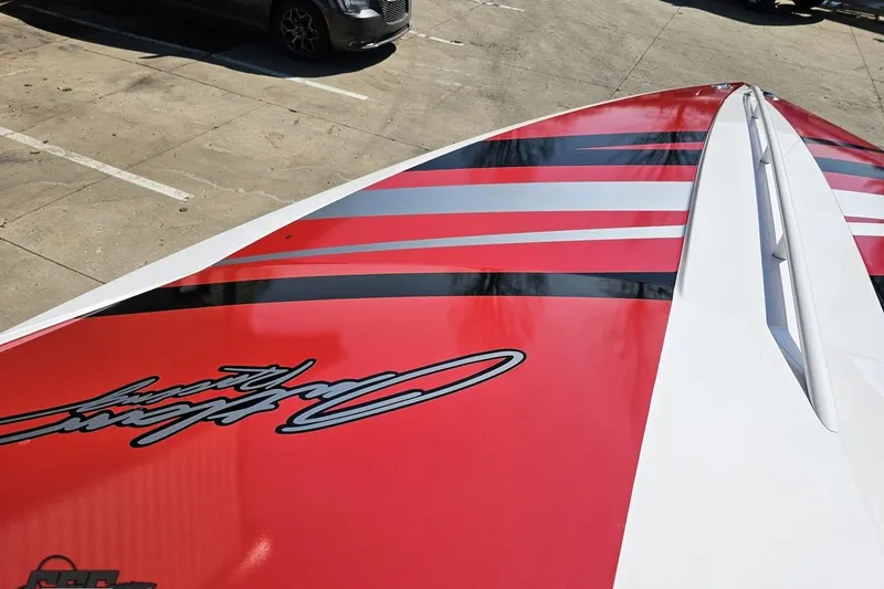 Slide: The Image of 2018 Baja 24 Outlaw boat with red and black striped design on deck. - 82