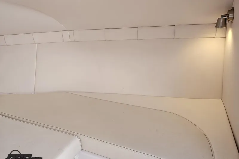 Slide: The Image of Interior cabin of 2018 Baja 24 Outlaw boat, featuring white upholstery and ambient lighting. - 86