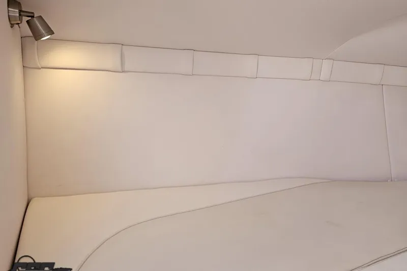Slide: The Image of Interior cabin of a 2018 Baja 24 Outlaw boat with white upholstery and lighting. - 87