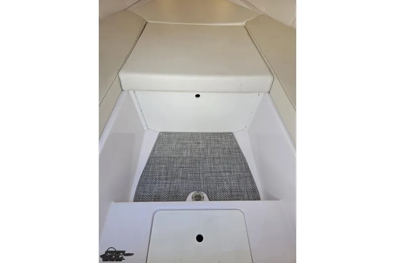 Slide: The Image of 2018 Baja 24 Outlaw boat interior with cushioned seating and carpeted flooring. - 88