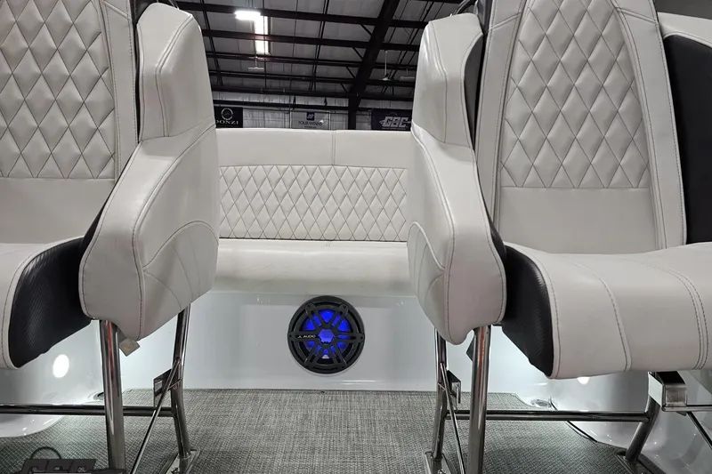 Slide: The Image of Interior of 2018 Baja 24 Outlaw boat with diamond-stitched seats and blue speaker. - 90
