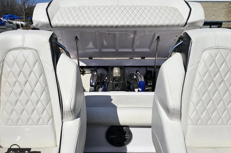 Slide: The Image of 2018 Baja 24 Outlaw boat interior with open engine compartment and white quilted seats. - 93