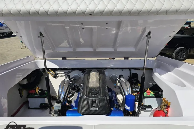 Slide: The Image of 2018 Baja 24 Outlaw boat engine compartment with open hatch, showcasing engine components. - 94