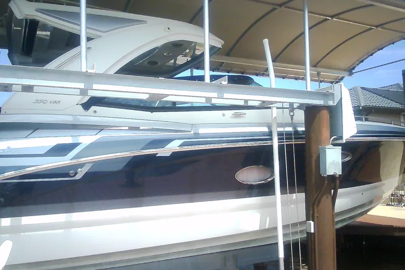 Slide: The Image of 2020 Formula 350 Crossover Bowrider boat docked under a canopy. - 12