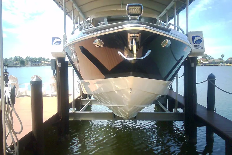 Slide: The Image of 2020 Formula 350 Crossover Bowrider on a boat lift by the water. - 16