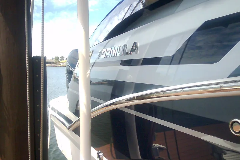 Slide: The Image of 2020 Formula 350 Crossover Bowrider docked, showcasing sleek design and branding. - 20