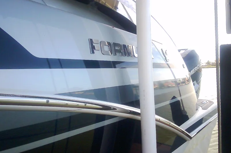 Slide: The Image of 2020 Formula 350 Crossover Bowrider boat docked, showcasing sleek design and branding. - 22