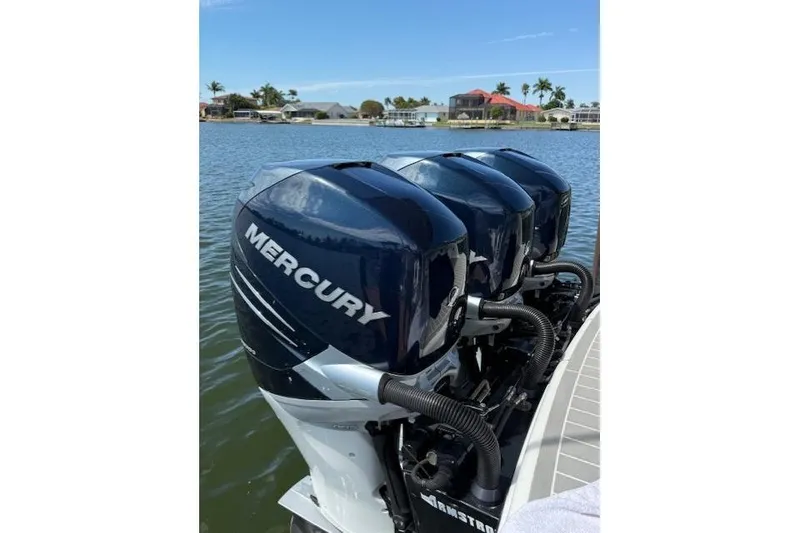 Slide: The Image of Four Mercury outboard engines on a 2020 Formula 350 Crossover Bowrider, docked by a scenic waterfront. - 3