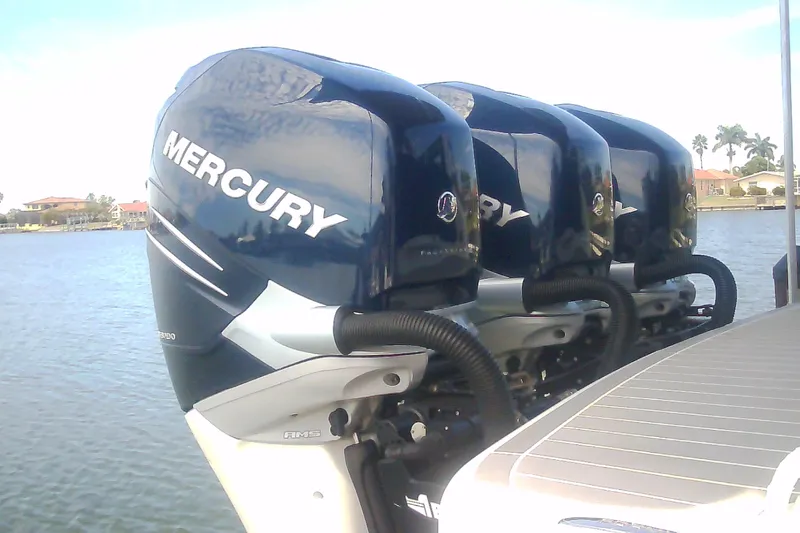 Slide: The Image of Triple Mercury outboard engines on a 2020 Formula 350 Crossover Bowrider, docked by the water. - 4