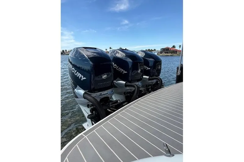 Slide: The Image of Triple Mercury outboard engines on a 2020 Formula 350 Crossover Bowrider, docked by the water. - 9