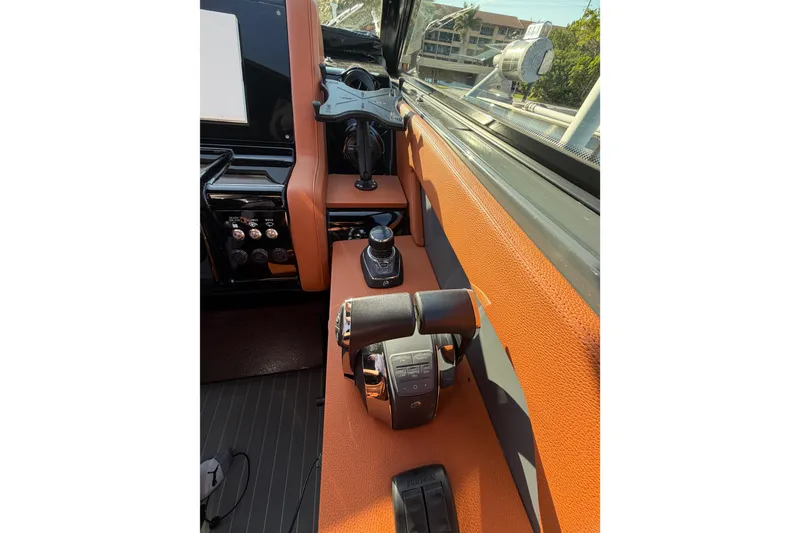 Slide: The Image of 2022 Cruisers Yachts 38 GLS OB helm with modern controls and orange upholstery. - 12