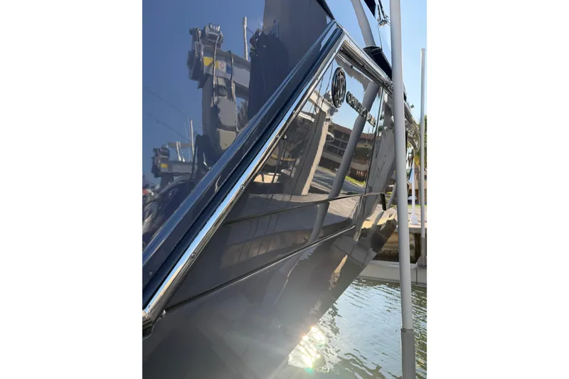 Slide: The Image of 2022 Cruisers Yachts 38 GLS OB, sleek hull design reflecting marina surroundings. - 13