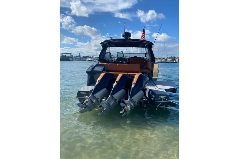 Slide: The Image of 2022 Cruisers Yachts 38 GLS OB in water, rear view with triple outboard engines. - 2