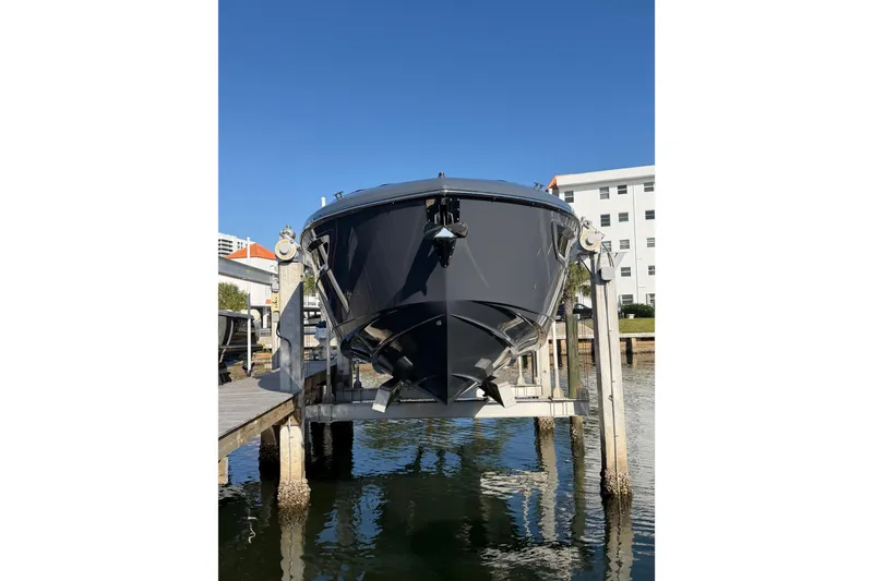 Slide: The Image of 2022 Cruisers Yachts 38 GLS OB on lift at marina, clear sky background. - 4