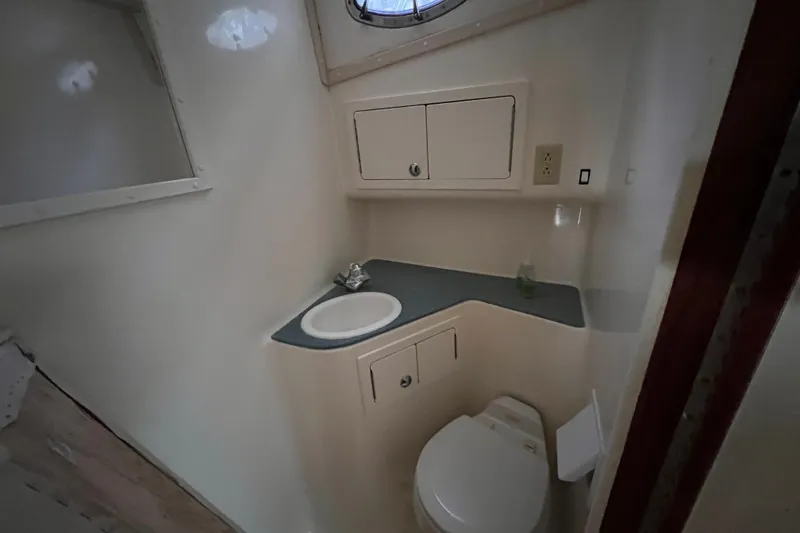 Slide: The Image of 2005 Carolina Classic 35 boat bathroom with sink, toilet, and storage cabinets. - 13