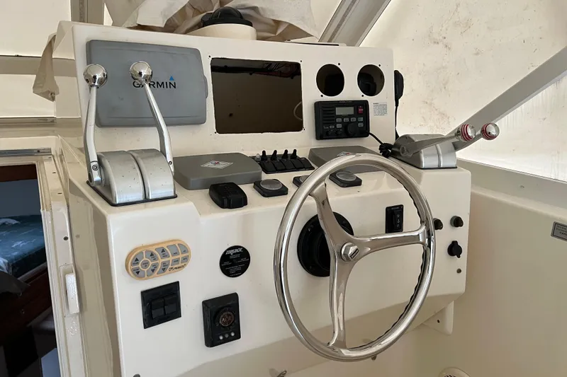 Slide: The Image of 2005 Carolina Classic 35 boat helm with steering wheel and navigation controls. - 6