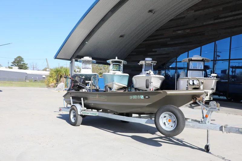 Slide: The Image of 2021 Gator Trax 1654 boat on trailer outside modern building. - 1