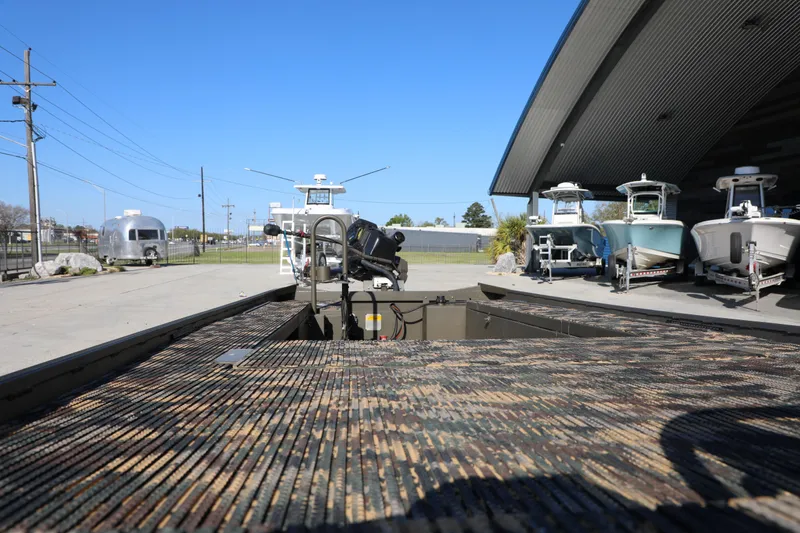 Slide: The Image of 2021 Gator Trax 1654 boat with camo deck, parked near other boats and trailers. - 4