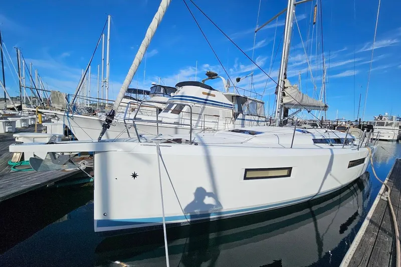 Slide: The Image of 2018 Jeanneau Sun Odyssey 440 sailboat docked at marina under clear blue sky. - 1