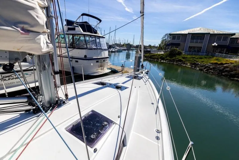 Slide: The Image of 2018 Jeanneau Sun Odyssey 440 sailboat docked in a marina under clear skies. - 2