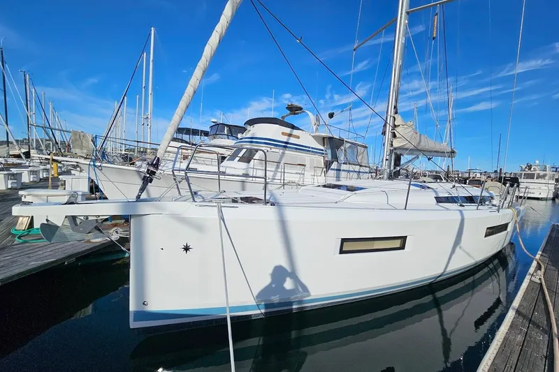Slide: The Image of 2018 Jeanneau Sun Odyssey 440 sailboat docked at marina under clear blue sky. - 26