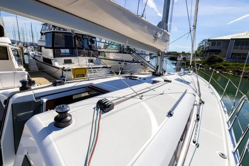 Slide: The Image of 2018 Jeanneau Sun Odyssey 440 sailboat docked at a marina, showcasing deck and rigging. - 3
