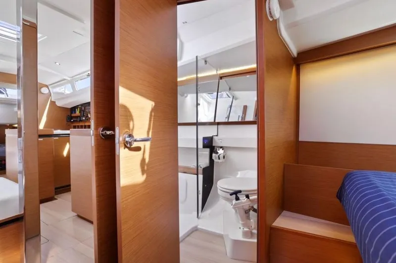 Slide: The Image of Interior of 2018 Jeanneau Sun Odyssey 440 yacht, featuring modern wood finishes and compact bathroom. - 6
