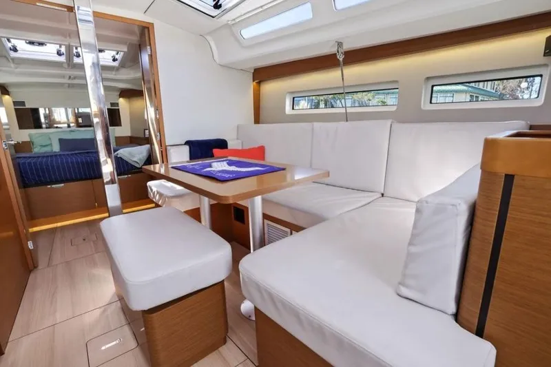 Slide: The Image of Interior of 2018 Jeanneau Sun Odyssey 440 yacht with modern seating and dining area. - 9
