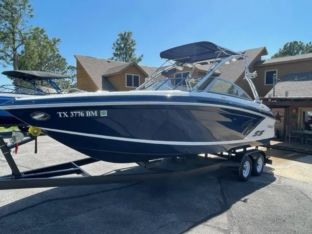 Slide: The Image of 2011 Cobalt 242 WSS boat docked, featuring spacious seating and teak swim platform. - 3
